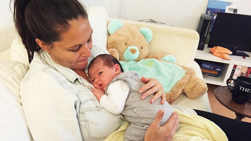 New mum Josie Sargent cradles her weeks-old son at home
