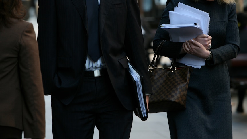 Workers carry documents in Sydney