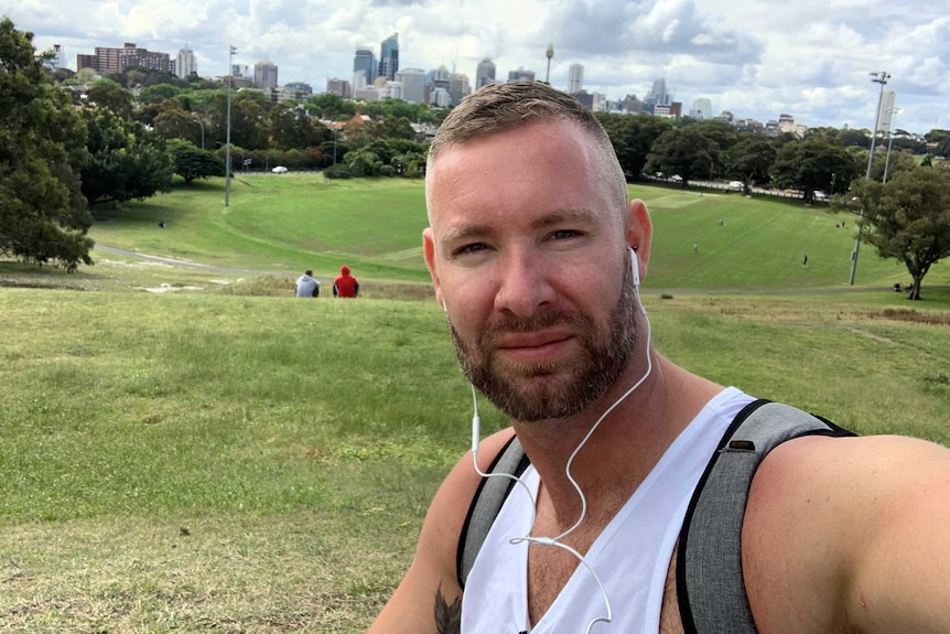 Mr Woodward is picture taking a selfie in a park in Sydney.