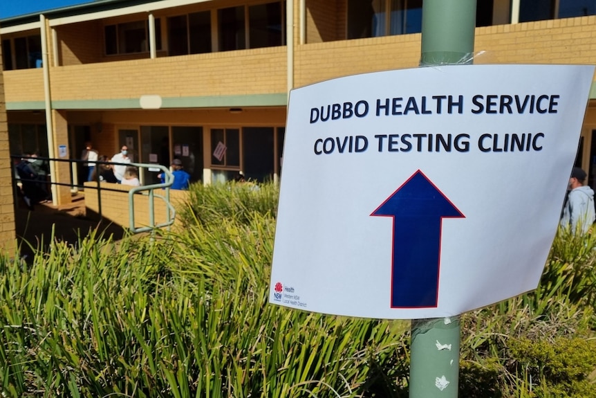 A temporary sign tacked to a pole showing the way to a COVID-19 testing clinic 