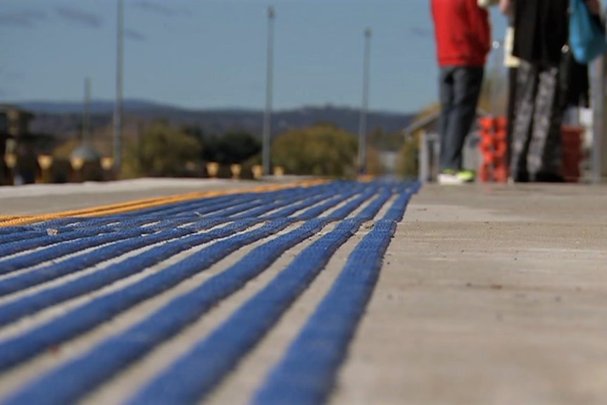 People standing on a train platform.