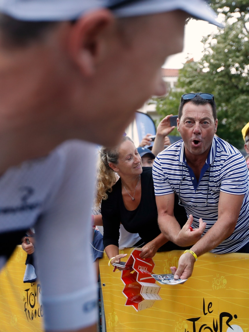 A man makes an injecting gesture towards Chris Froome