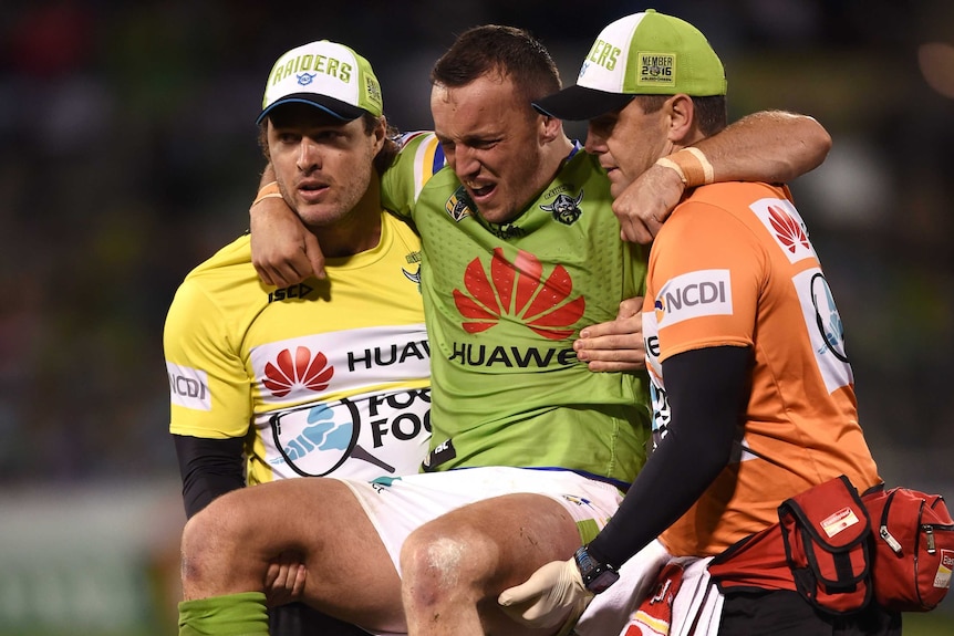 Josh Hodgson is carried from the ground by trainers