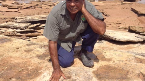 Micklo Corpus Yawuru traditional owner shows a dinosaur footprint near Broome in Western Australia