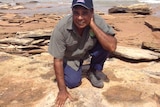 Micklo Corpus Yawuru traditional owner shows a dinosaur footprint near Broome in Western Australia