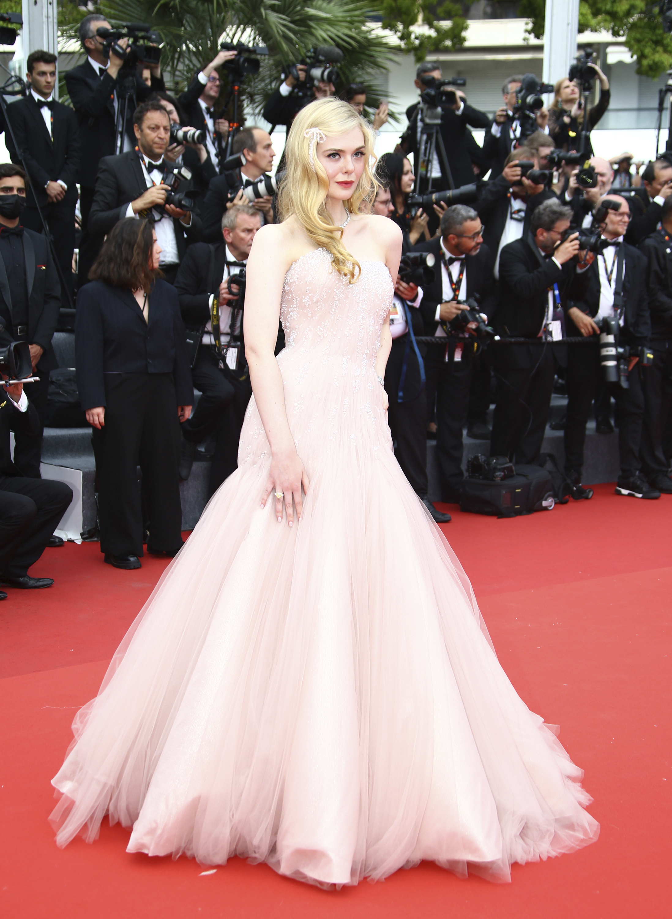 Elle Fanning wearing a strapless pale pink gown with a tulle skirt. 