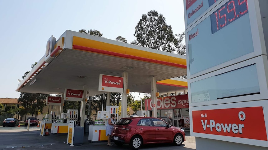 Cars at bowsers at petrol station with fuel prices sign at Daisy Hill, south of Brisbane, on September 11, 2018