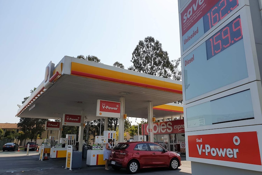 Cars at bowsers at petrol station with fuel prices sign at Daisy Hill, south of Brisbane, on September 11, 2018