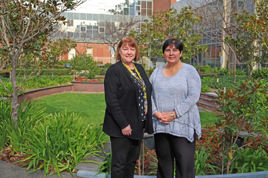 Nurses Kathryn Resili and Karen Hales in the garden of their Adelaide hospital.