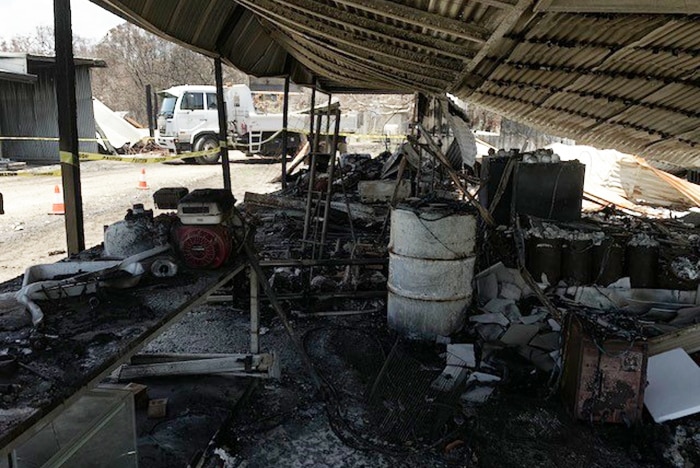 Damaged equipment and shed after a bushfire at apiarist George Spiteri's property at Deepwater.