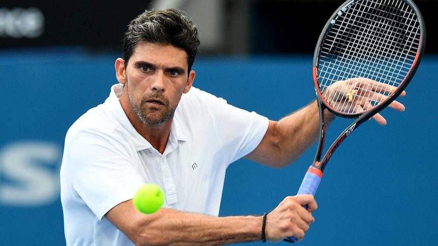 Mark Philippoussis of Australia returns a shot as a tennis ball heads towards him