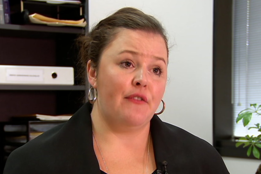 Ruth Parker speaks in an office during a TV interview.