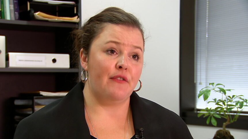 Ruth Parker speaks in an office during a TV interview.