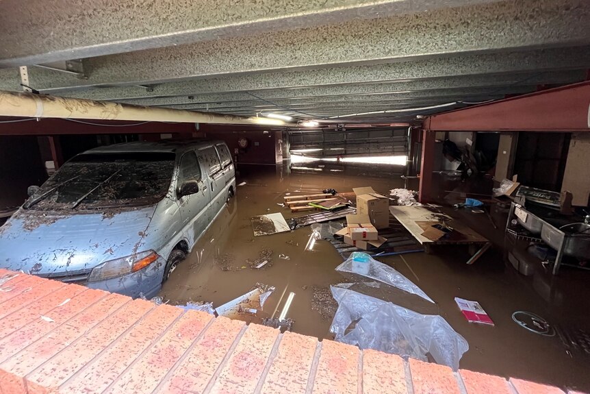 A car in a flooded basement carpark.