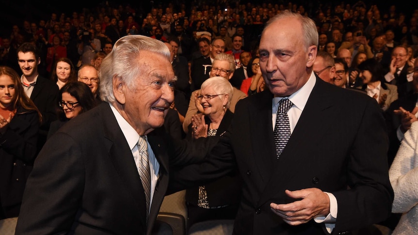 Paul Keating and Bob Hawke stand next to each other in suits