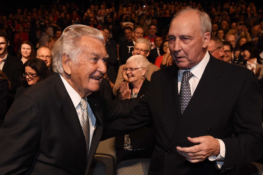 Paul Keating and Bob Hawke stand next to each other in suits