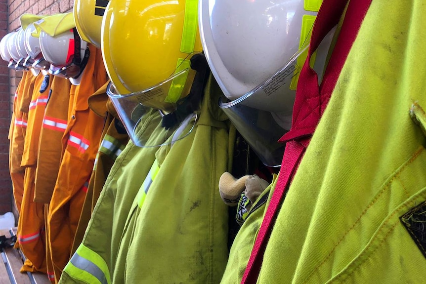 Firefighting helmets and clothing hanging on wall in Tasmanian rural fire station.