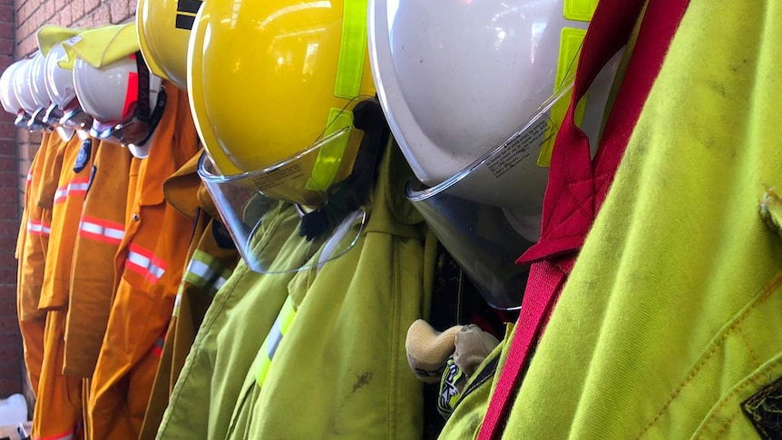 Firefighting helmets and clothing hanging on wall in Tasmanian rural fire station.