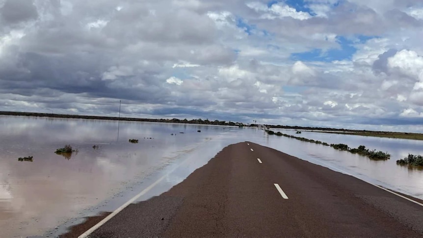 A remote road blocked by flood water.