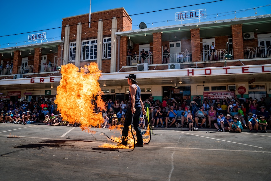 Man whip cracking a whip that's on fire