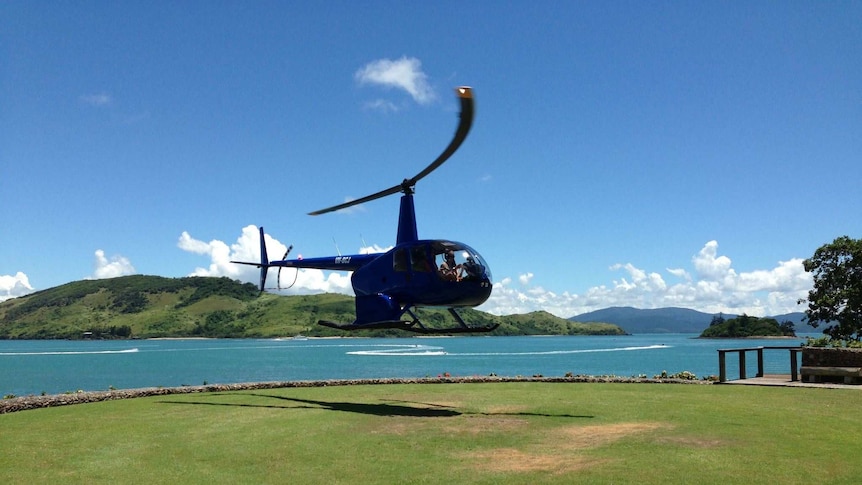 A helicopter lands at The Qualia helipad on Hamilton Island.