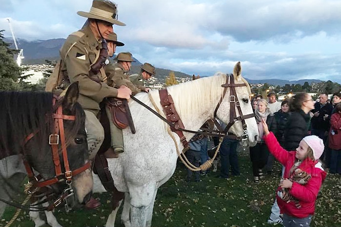 A horse receives a pat at Hobart Anzac Day dawn service, 2018.