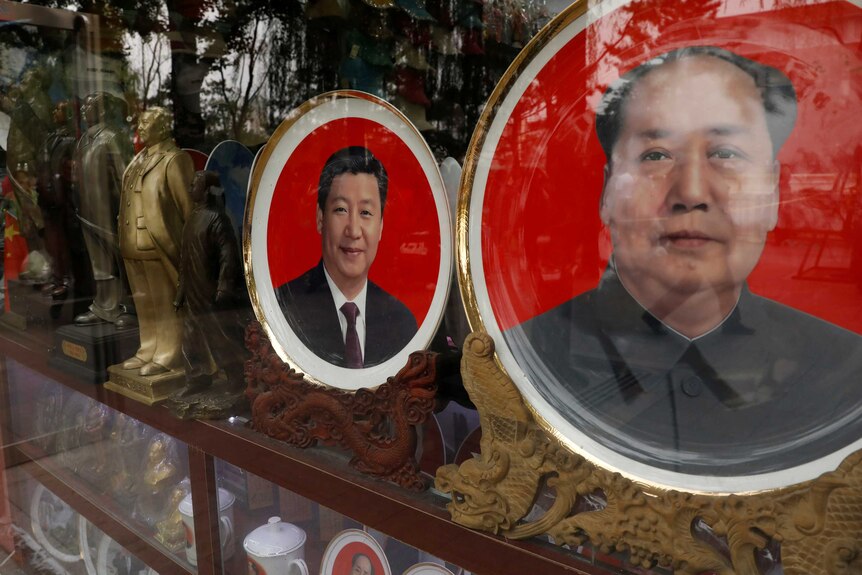 Xi Jinping and Mao Zedong appear on plates for sale in a store window.