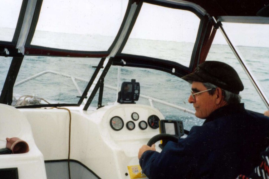 A man behind the wheel of a boat at sea