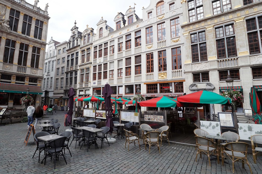 Empty tables and chairs in Brussels' Grand Place square.