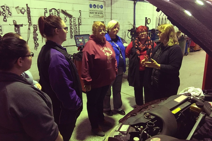 The women learn how to check radiator fluid.
