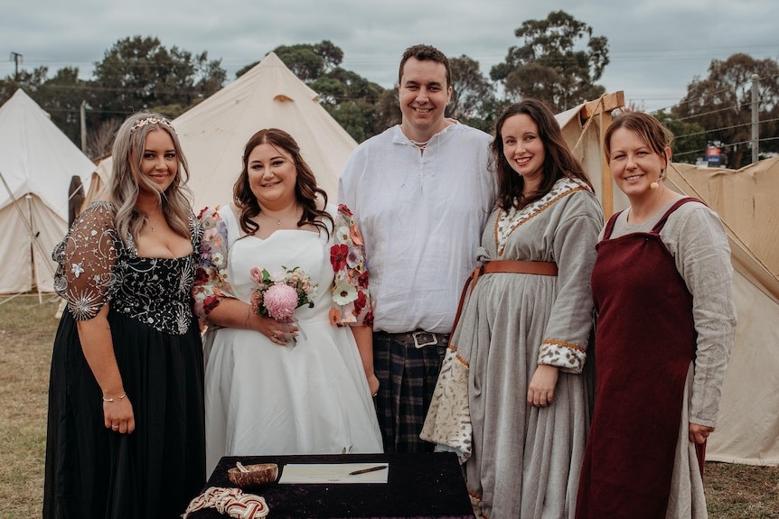 A bride and groom stand with their witnesses and the celebrant after being married