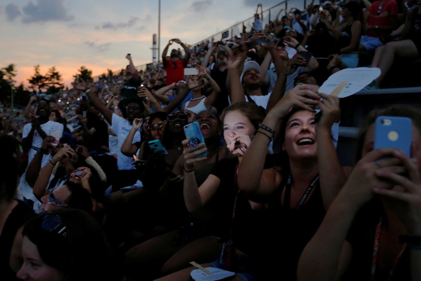 A crowd reacts to the total eclipse in a football stadium