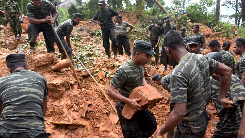 Sri Lankan military personnel work in an area hit by a landslide.