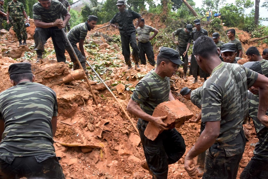Sri Lankan military personnel work in an area hit by a landslide.