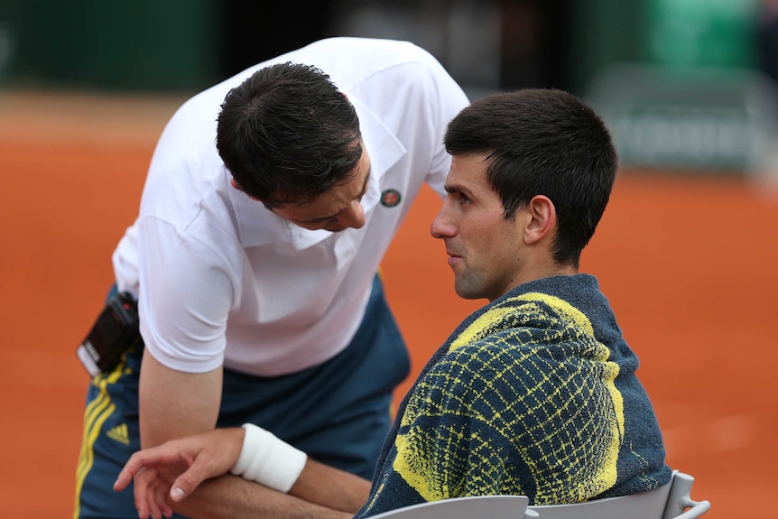 Treatment needed ... Novak Djokovic receives assistance from a trainer during his match against Grigor Dimitrov
