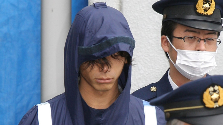 Tatsuya Ichihashi, a suspect in the killing of British woman Lindsay Ann Hawker, is escorted by policemen