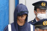 Tatsuya Ichihashi, a suspect in the killing of British woman Lindsay Ann Hawker, is escorted by policemen