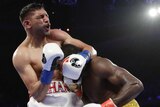 Amir Khan winces after getting hit with a low blow by Terence Crawford in their welterweight boxing fight.