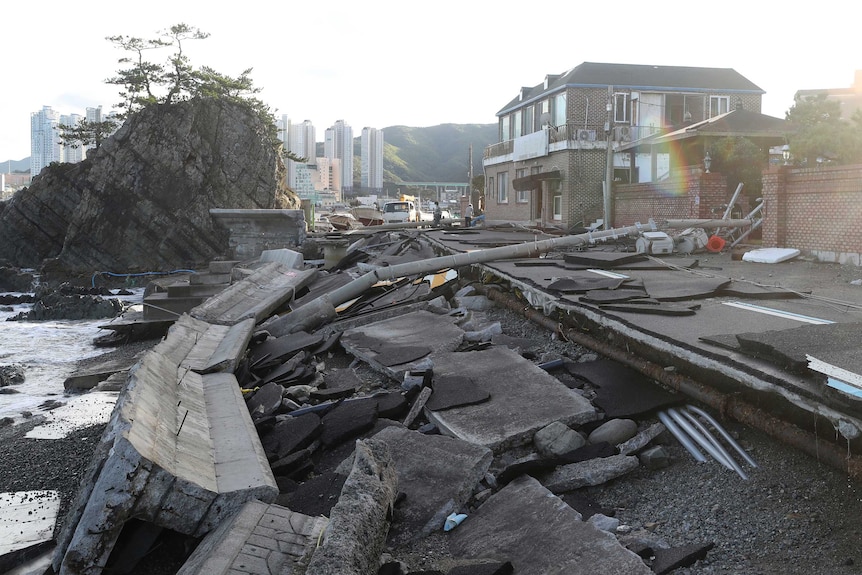 Damaged road with city buildings in background