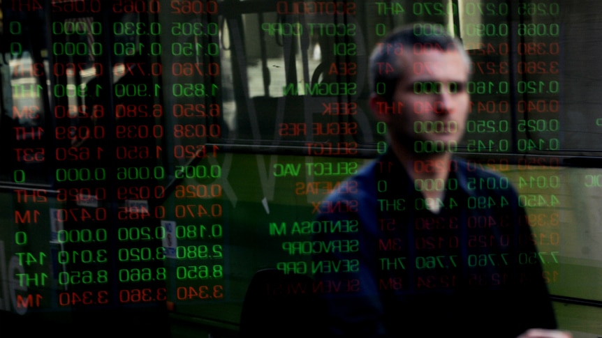 Office workers and passers-by watch the share market prices at the Australian Stock Exchange.