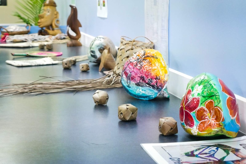 Display of south sea islander cultural items, including brightly painted coconuts.