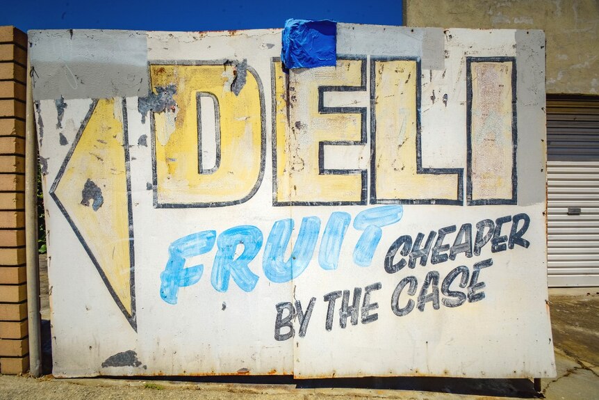 Faded signwriting on a closed deli and fruit vendor on a neighbourhood street corner in East Victoria Park