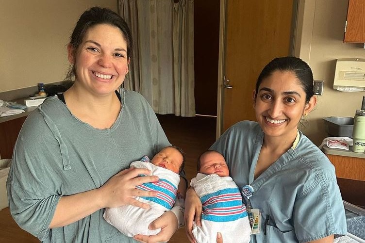 두 여성, 어머니, 의사가 여자 아기를 안고 있습니다. 