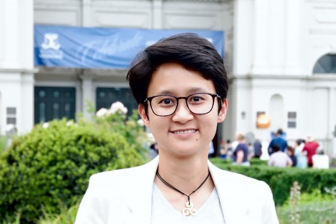 A woman wears glasses and poses for a photo in front of Melbourne Exhibition Centre