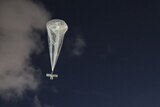 A high-altitude balloon carrying solar panels floats in the sky.