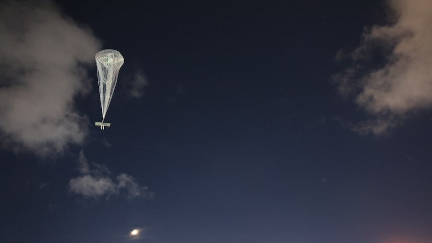 A balloon carrying solar panels floating in the air. 
