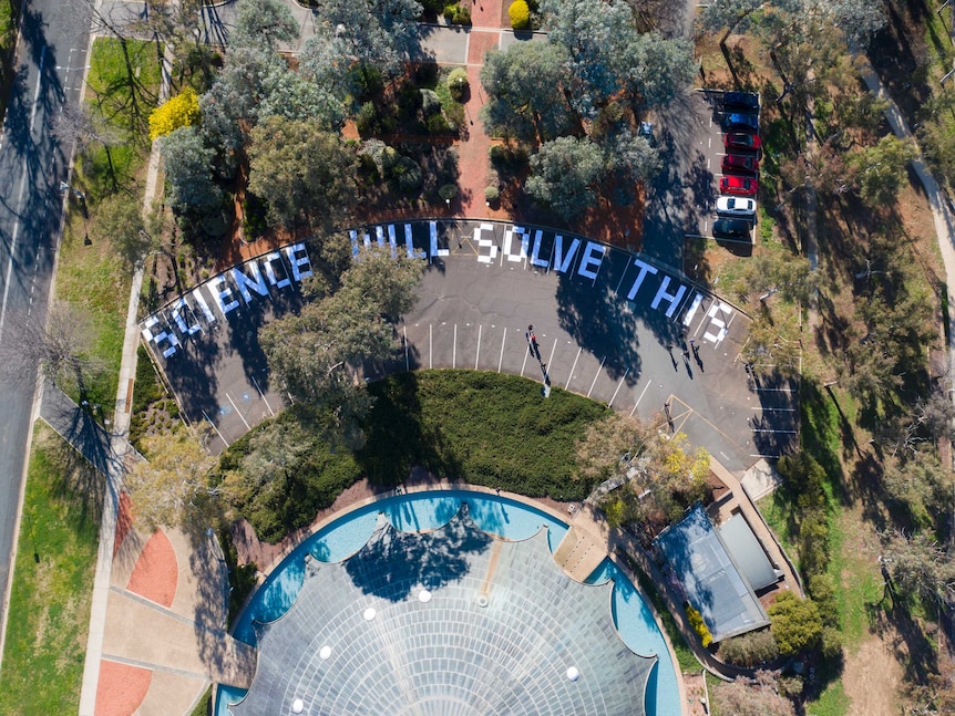 Aerial image of the shine dome with the words Science Will Solve This written in the car park.