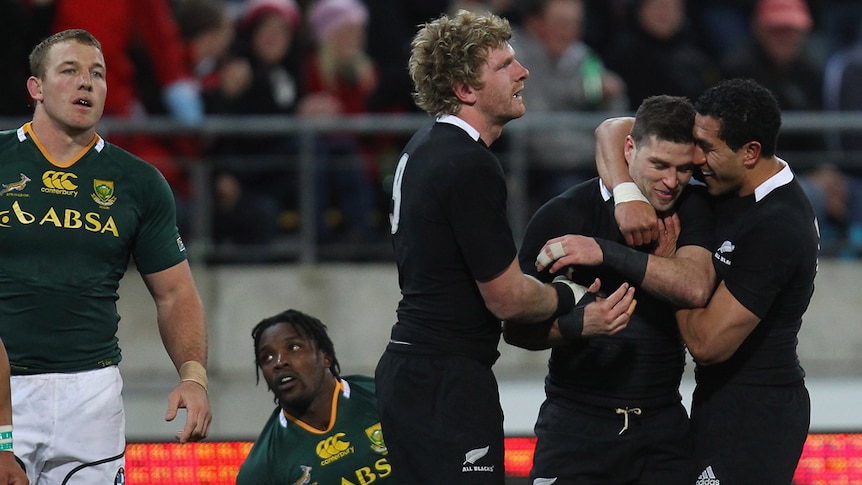 All Blacks Adam Thomson (L) and Mils Muliaina (R) congratulate Cory Jane on his try against the Boks