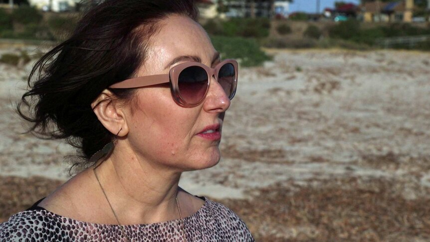 Kylie Walsh wears sunglasses on the beach