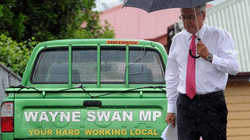 Wayne Swan walks past his electorate-office ute